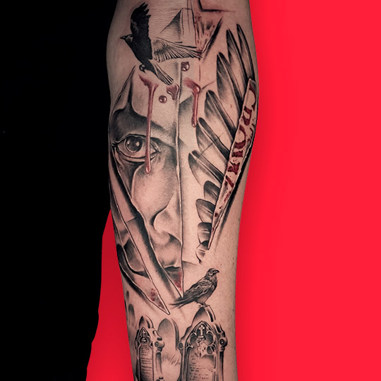 Tatuaje trash polka abstracto con motivos de cementerio y rostro de hombre con tonos de color rojo y en blanco y negro. Tatuaje trash polka en antebrazo exterior