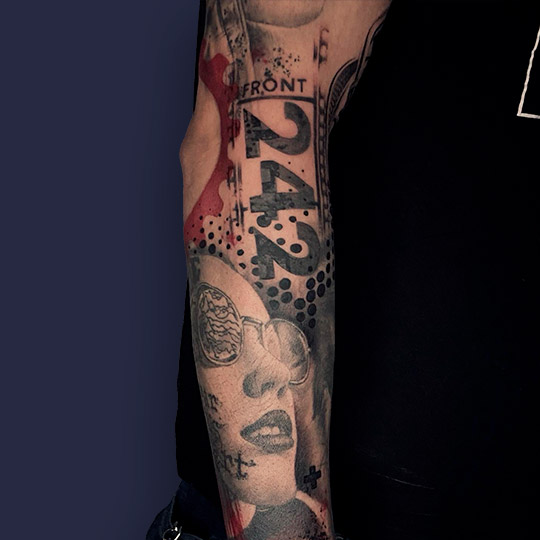 Tatuaje trash polka con rostro de mujer y número 242 con tonos de color rojo y en blanco y negro. Trash polka tatoo en brazo hombre